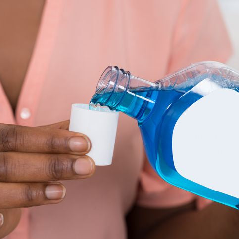 Person-Pouring-Mouthwash-Into-Bottle-Cap-622201158_727x485